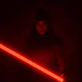 Portrait of a silhouette star wars figure in her red lightsaber, in the style of evocative environmental portraits, dark, red