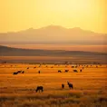 A panoramic view of a vast, golden savannah at dawn, with herds of wildlife grazing and a distant, snow-capped mountain range on the horizon.